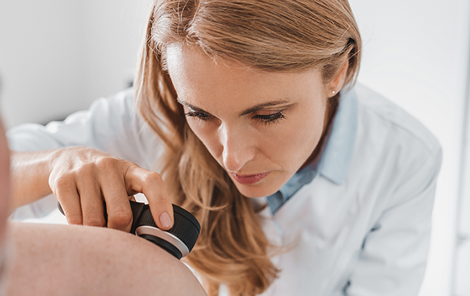 doctora observando detalladamente lesiones de un paciente con hidradenitis supurativa