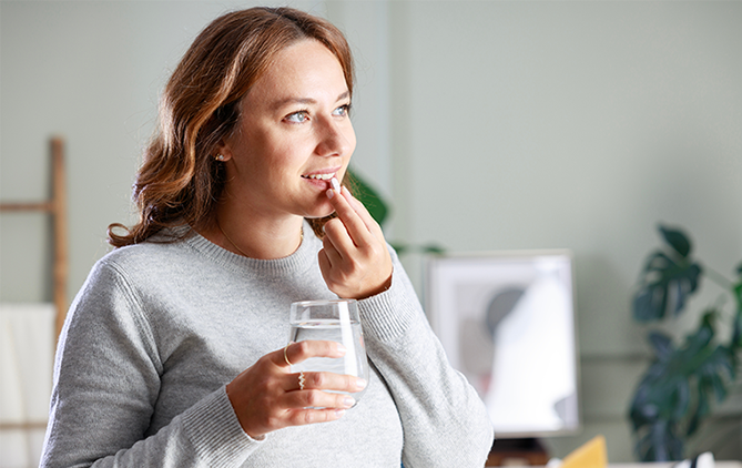 04_Medicamento.png mujer tomando unas pastillas sujetando un vaso de agua