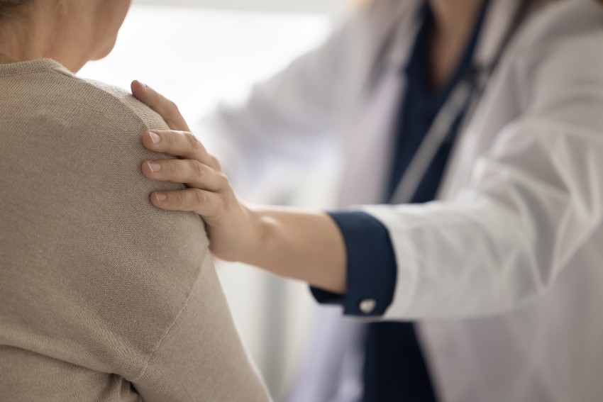 doctora toca por los hombros al paciente