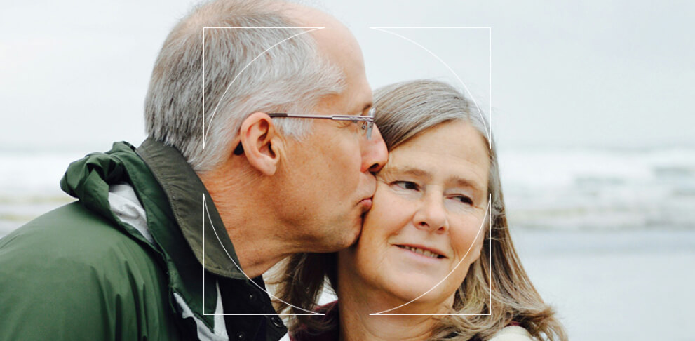 Elderly man kissing his wife on the cheek