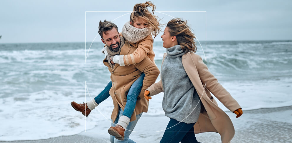 Family walking on the beach in the wind